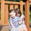 Due bambini seduti sul Nature Ship Sandbox, wooden playhouse in legno.