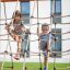 Bambini che si arrampicano su una rete di corda Nature Ship Sandbox, wooden playhouse.