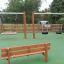 Larchwood Bench in un parco giochi con altalene sullo sfondo.