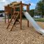Struttura da parco giochi in legno Alstad con scivolo ed elementi per arrampicarsi.
