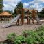 Set di attrezzature da parco giochi Alstad con scivolo, parete da arrampicata e strutture in legno.