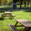 Larchwood Table & Bench in un contesto di parco erboso.