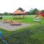 Larchwood Table & Bench posizionato in un'area giochi all'aperto.