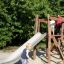 Bambini che giocano sulla struttura dello scivolo in legno Bergila.