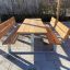 Set in legno 'Table & Bench' su un patio, perfetto per sedersi all'aperto.