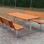 Set Table & Bench da esterno con sedute in legno e struttura in metallo su una superficie pavimentata.