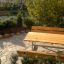 Table & Bench da esterno in legno allestito in un giardino.
