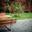 Table & Bench in un parco con sfondo di erba verde e fogliame dai colori autunnali.