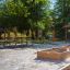 Set di mobili da esterno Table & Bench in un parco con sabbiera nelle vicinanze.
