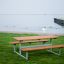 Set Table & Bench all'aperto vicino a un lungomare con area erbosa.