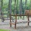 Ponte da parco giochi in legno Dolomiti in un parco rigoglioso.