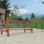 Dolomiti struttura da arrampicata in legno per parco giochi con elementi in corda su superficie sabbiosa.