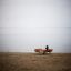Allestimento all'aperto Table & Bench Quadro su una spiaggia sabbiosa con un lago sullo sfondo.