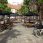 Sedute pubbliche all'aperto con set Table & Bench Quadro sotto gli ombrelloni.