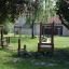 Attrezzatura da parco giochi in legno da esterno Sintra in un giardino sul retro verde.