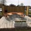 Set da esterno School Table & Bench in un'area pavimentata con pannelli divisori in legno.