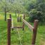 Struttura da arrampicata in legno per parco giochi per bambini chiamata Kongo in un contesto di parco verde.