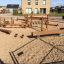 Kongo set da parco giochi realizzato con elementi in legno su una superficie di sabbia.