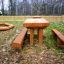 Table & Bench Nature in legno da esterno in un giardino sul retro.