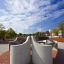 Panchina da esterno in cemento Dona dal design moderno in un parco pubblico.
