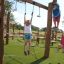 Bambini che giocano nel parco giochi con tappeto antitrauma da 45 mm con erba artificiale.