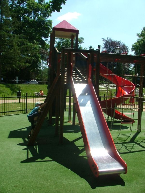 Tappeto antitrauma da 70 mm con erba artificiale sotto uno scivolo del parco giochi