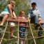 Bambini che giocano su Swallow climbing net in un parco giochi all'aperto.