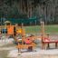 Parco giochi all'aperto con tettoia Sun Shade Square Atlantis (Metal) e strutture da gioco in legno.