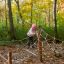 Bambino che gioca su Gossamer struttura da arrampicata in corda in un bosco autunnale.