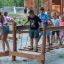 Bambini che giocano su Sahara ponte da arrampicata in legno per parco giochi all'aperto