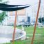 Sun Shades che fornisce copertura in un moderno contesto di parco urbano con un bambino seduto accanto a una fontana in cemento