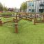 Struttura da gioco all'aperto Gobi con travi in legno ed elementi in corda in un parco giochi scolastico.