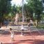 Bambini che giocano su una struttura da arrampicata a piramide con base Rubber Tiles 90 in un parco.