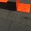 Rubber Tiles 90 di Lars Laj sotto una struttura arancione.