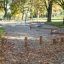 Area giochi all'aperto con la trave di equilibrio Cape Code e tronchi da equilibrio tra gli alberi in un parco.