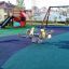Parco giochi con superficie wetpour e attrezzature da gioco all'aperto.