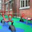 Parco giochi dotato di pavimentazione in gomma Wetpour 100 e altalene a bilico rosse.