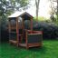 Casetta da gioco in legno per bambini all'aperto 'Veranda House Nature' in un giardino.