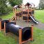 Knight's Castle Nature playhouse with slide e tunnel in un parco.