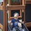 Bambino che scende dallo scivolo di Knight's Castle Nature playhouse with slide.