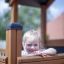 Bambino che gioca in Tower Nature wooden playhouse with slide.