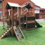 Casetta gioco in legno con scivolo in un parco giochi.