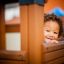 Bambino che gioca in Fortress Nature playhouse with slide