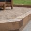 Fortress Nature playhouse with slide in un'area sabbiera in legno