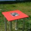 Sand & Water Table con parte superiore rossa e vasca in acciaio inox su un prato