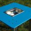 Sand & Water Table con superficie blu e vasca in acciaio inox al centro, collocato all'aperto.