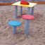 Table and chair in un parco giochi per bambini con sedute colorate.