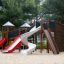 Mastodont castle with slide struttura per parco giochi con scivoli rossi e bianchi e parete da arrampicata sulla sabbia