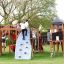 Bambini che giocano sul castello Mastodon con scivolo in un parco giochi.