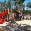 Castello Mastodon con scivolo in un parco giochi con bambini che giocano